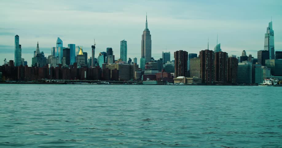 A boat moves past a city on a coast