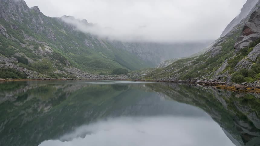 Landscape of a lake that reflects the mountains and the cloudy day around