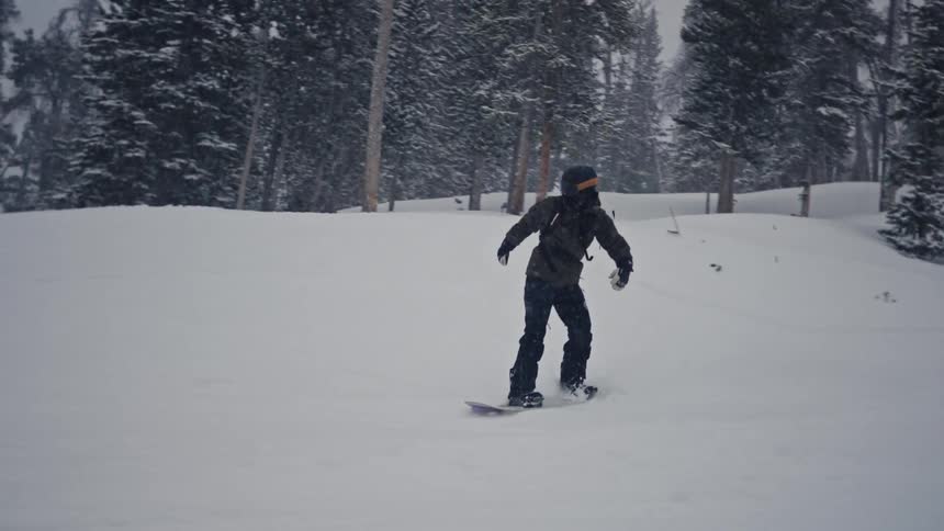 A snowboarder going down a slope