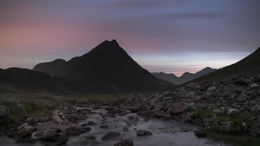 Landscape of rocks and mountains with the sky in aurora borealis timelapse