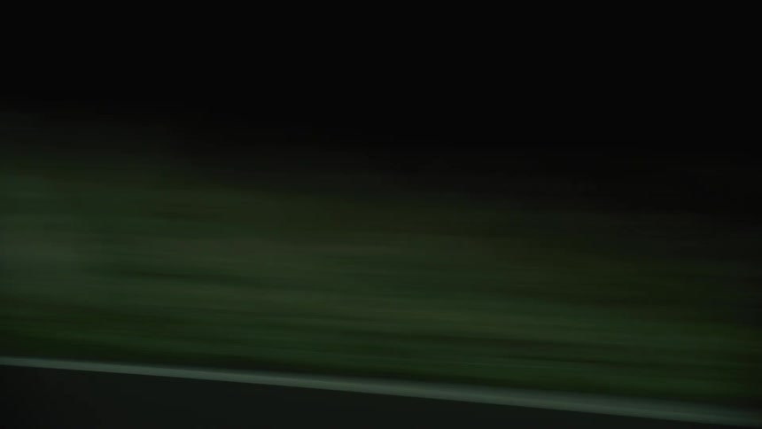 Vehicle drives along rural highway at night