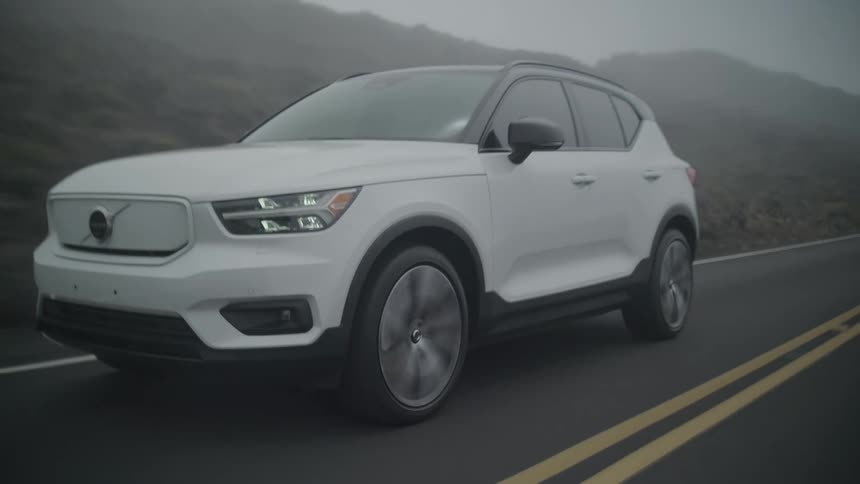 White luxury suv vehicle traveling on a paved road in nature