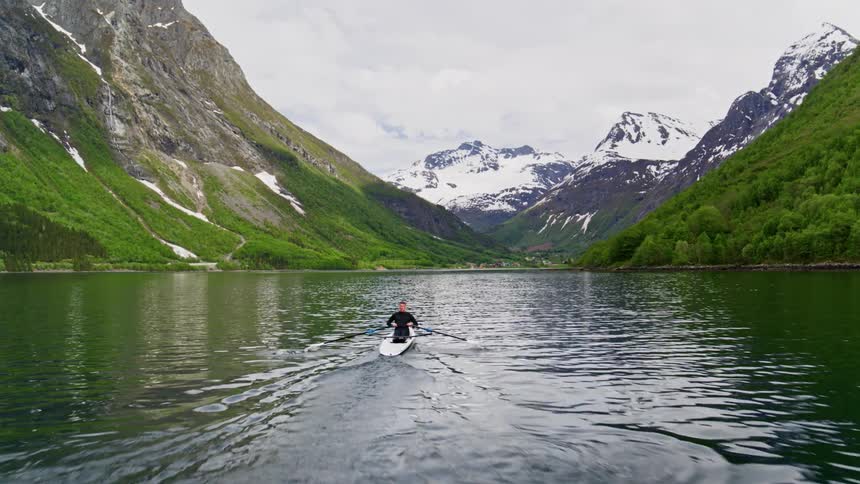 A man rowing a kayak through a lake
