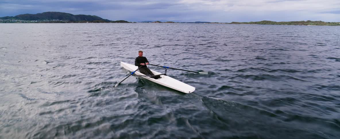 Aerial shot of an Olympic athlete rowing on choppy water