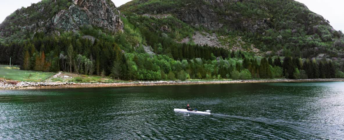 Stunning coastline and emerald green water with a man in a rowing boat