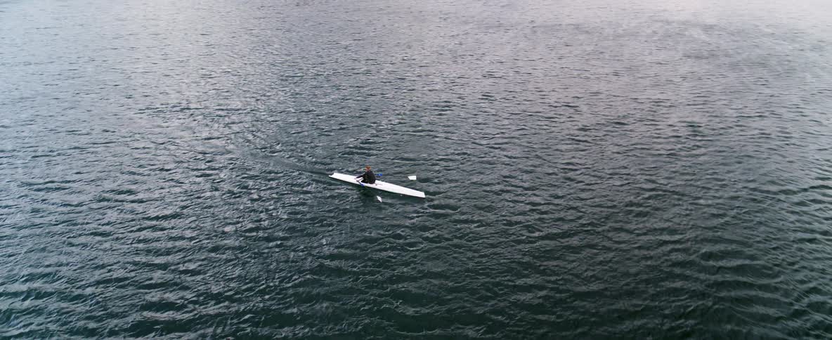 Vast water view of a rower making his way across an expansive body of water