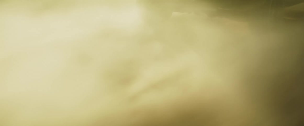 A car drives very fast over a dirt surface while it kicks up dust