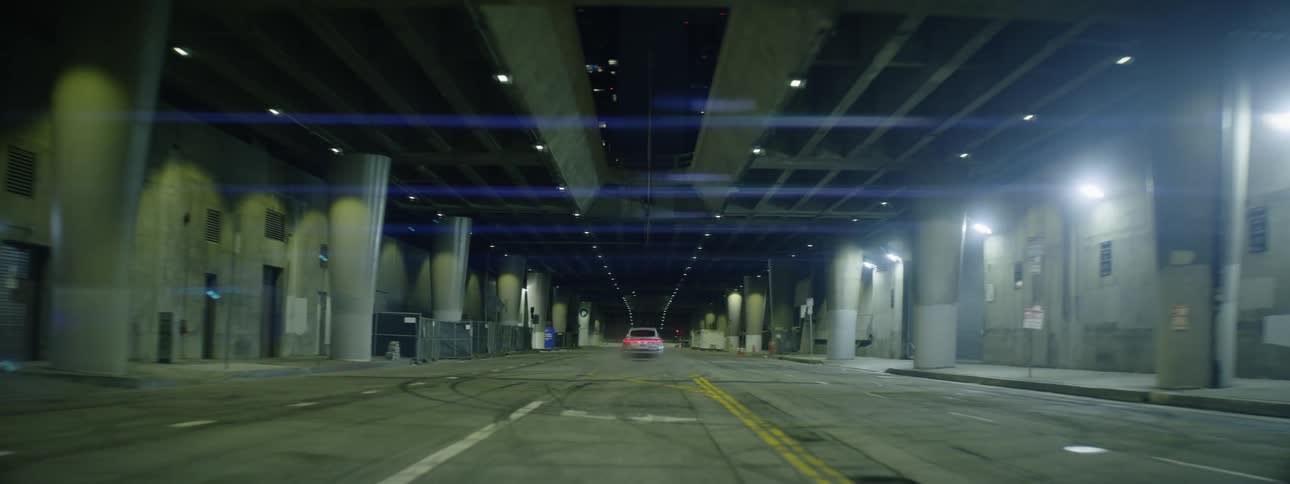 Silver audi speeding down a desert street in the city at night