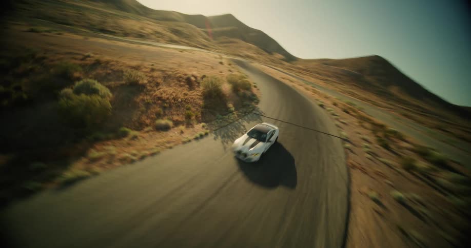 Aerial view sports car drivingthrough desert mountain landscape