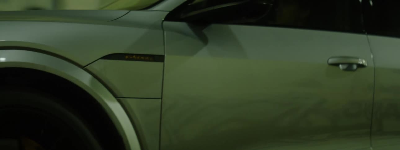 Gray vehicle moving through a tunnel at night in the city with alloy wheels and full led headlights