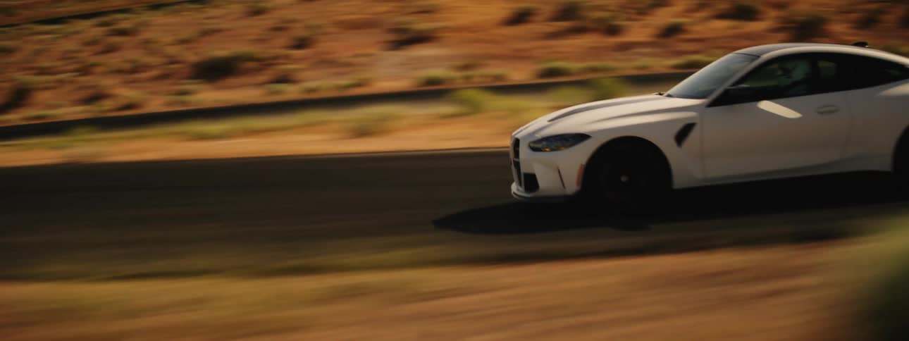 A white sport car driving on a lonely road in the valley