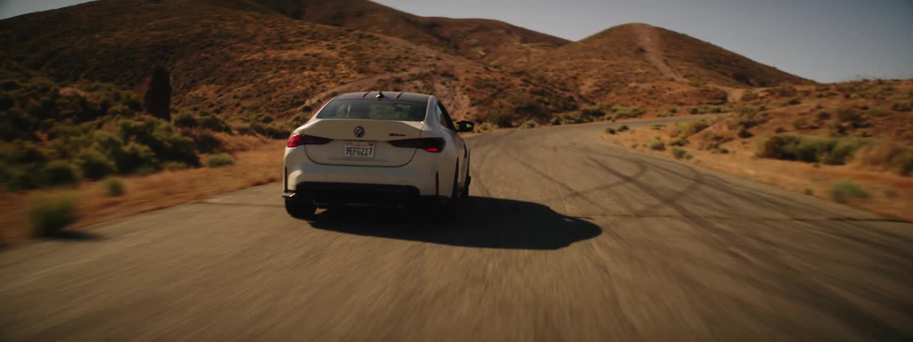 A car executes a sharp turn on a road in the desert