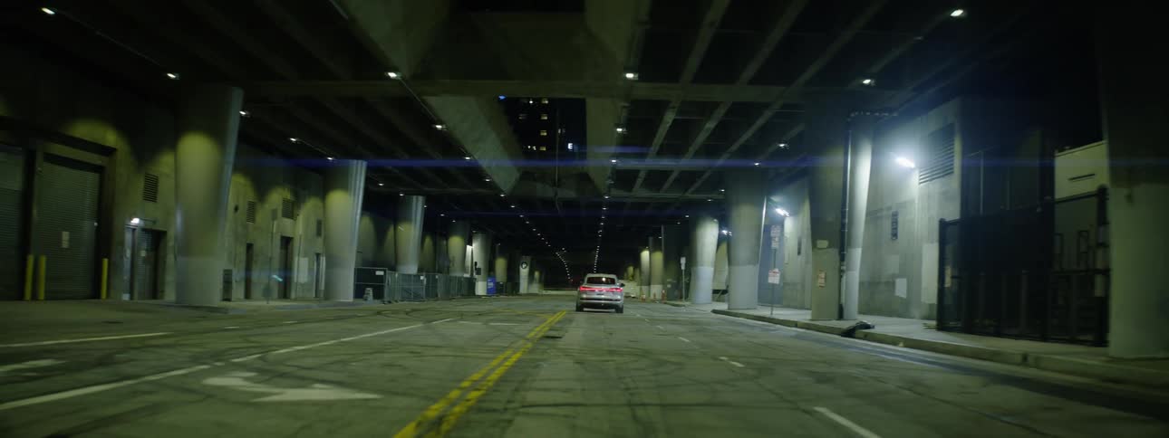 A silver audi suv traveling on a city street at night