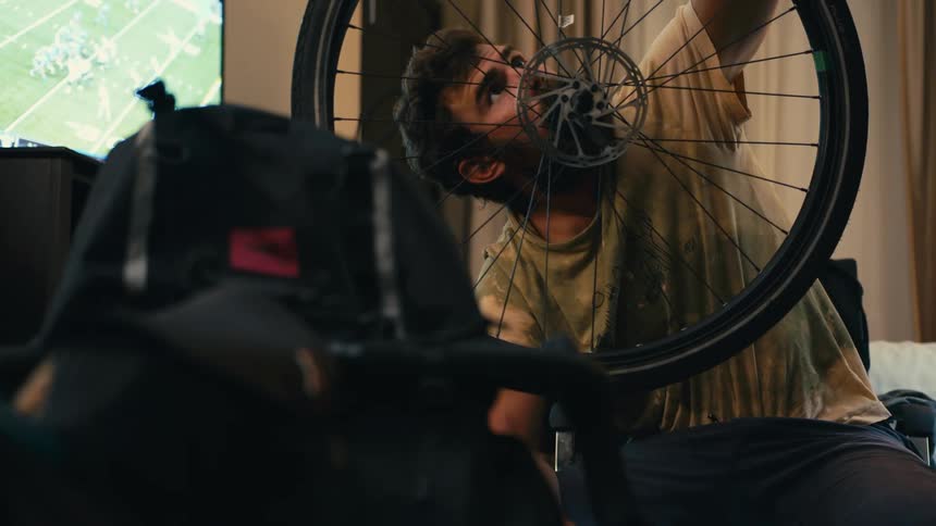 A man is repairing a bicycle tire at home