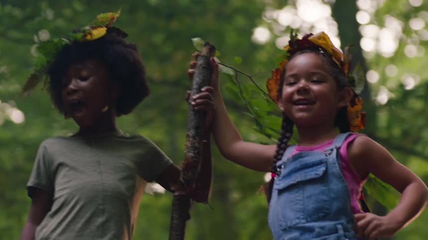 Two kids having fun singing in the woods