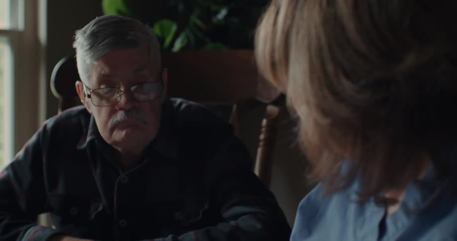 A grandfather and granddaughter discuss something together