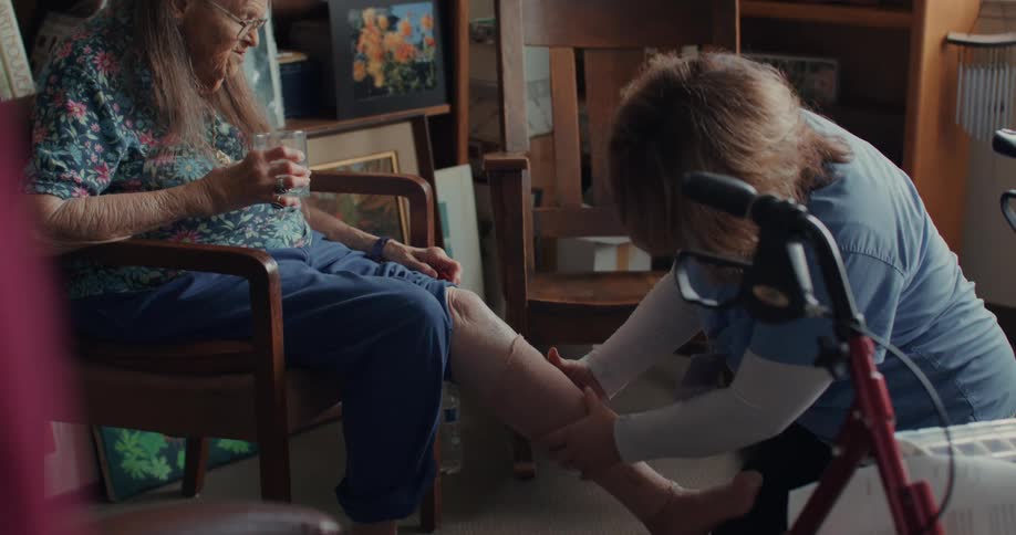 A nurse examines an elderly patients leg