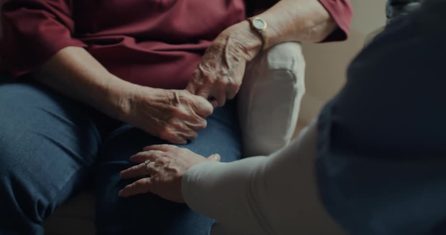 A nurse comforts an elderly patient