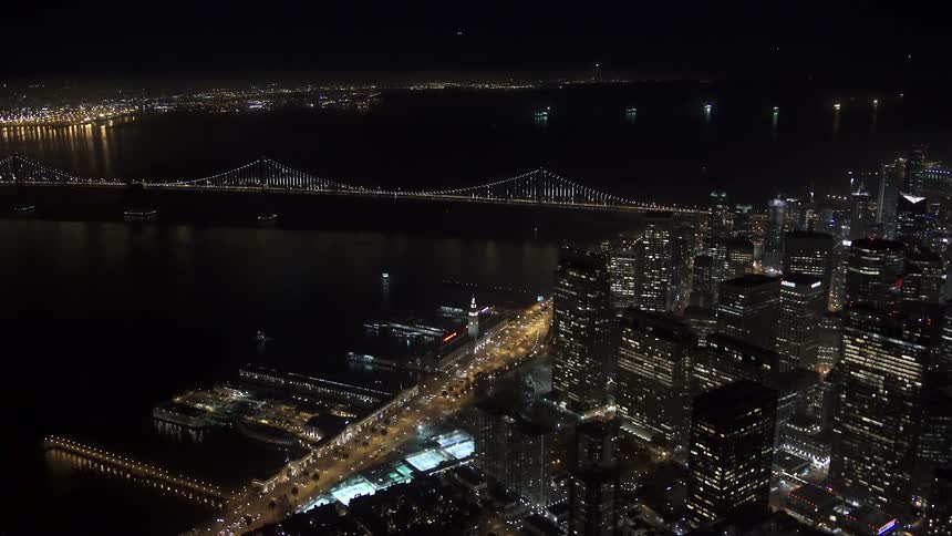 Aerial view of a river between two large cities at night