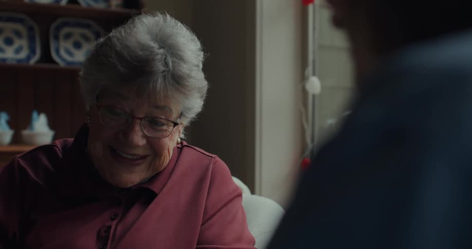 An elderly woman smiling while having a conversation