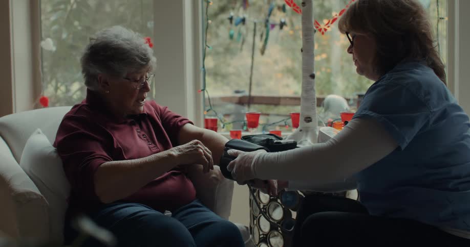 A nurse measures the blood pressure of an elderly lady