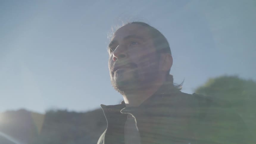 A man stands near a cliff
