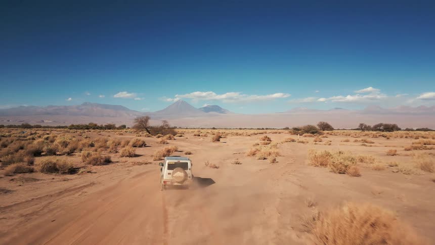 A truck gives off dust clouds driving off road in the desert