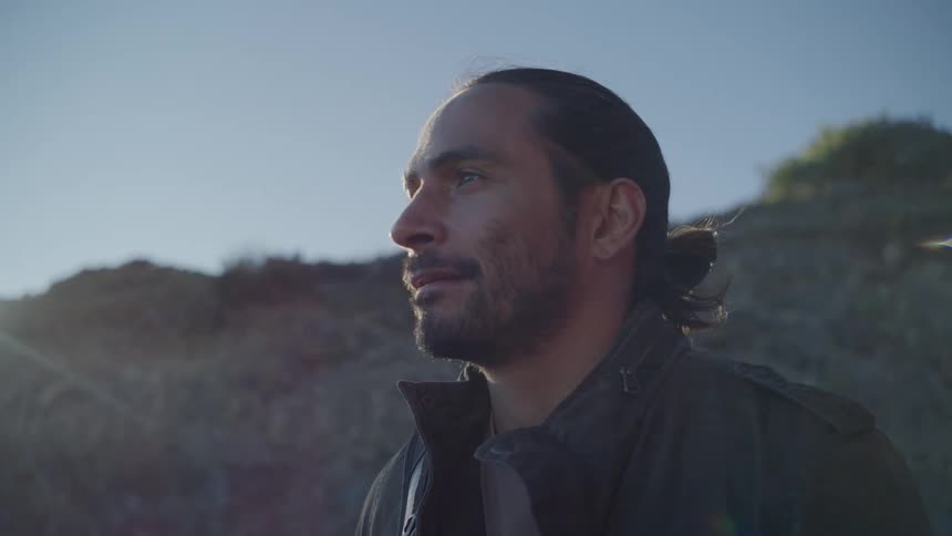 A man stands outside by a cliff