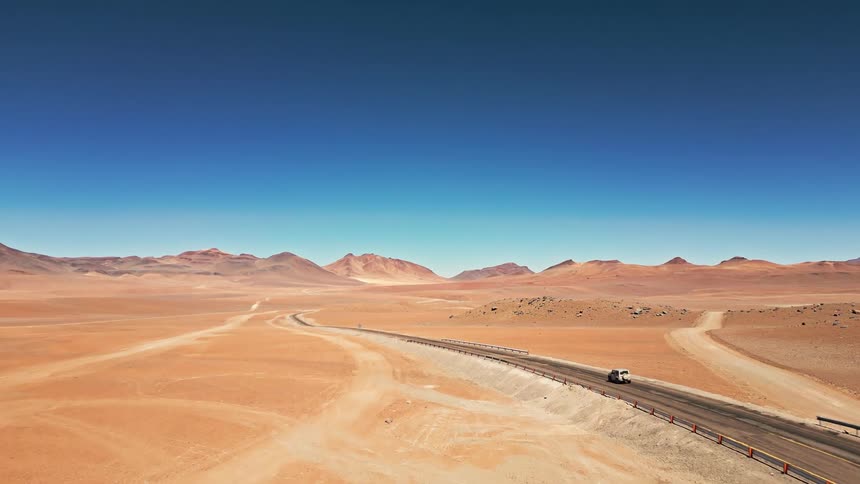 A jeep drives down the desert road