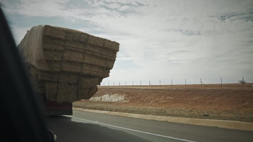 A truck carrying load is driving on the highway