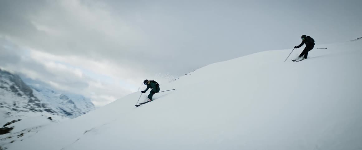 Two people are skiing on a snowcovered mountain