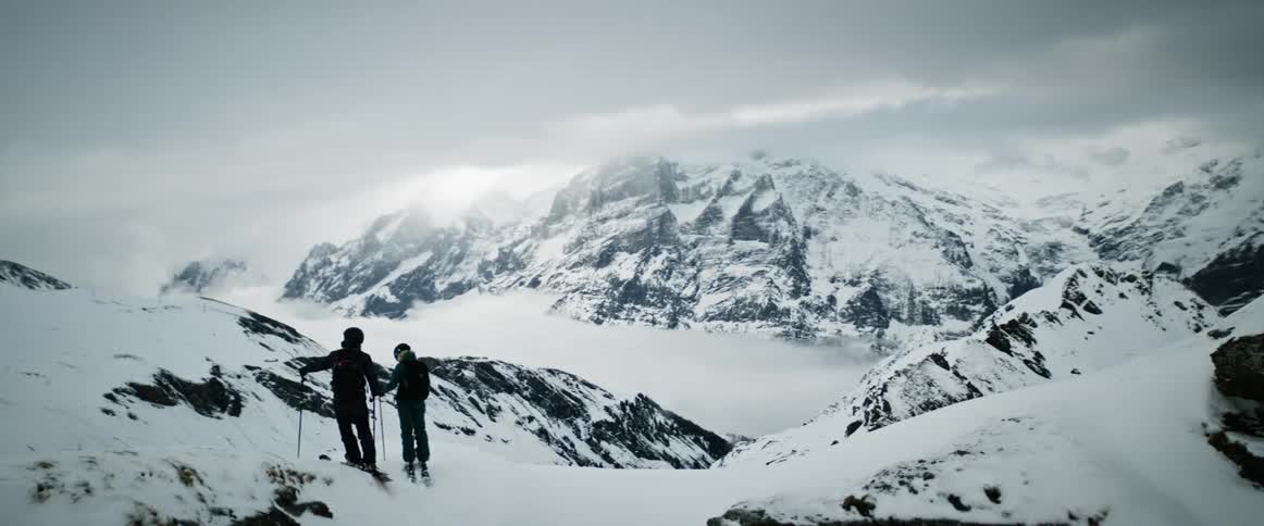 Two skiers stand together in nature
