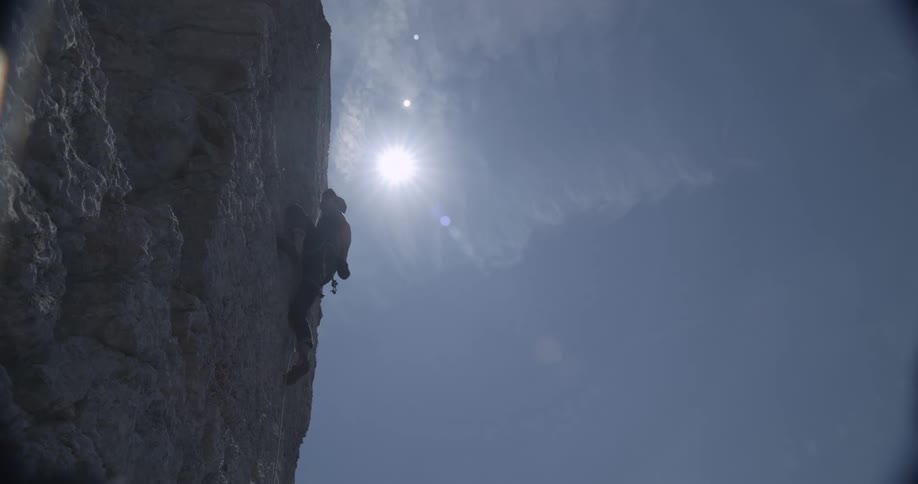 Man with safety equipment climbing a rock wall