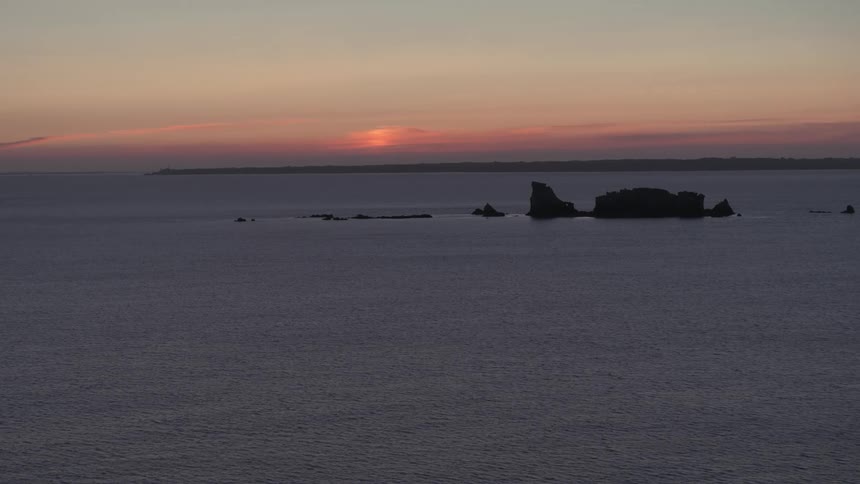 Small islands in the middle of the ocean at sunset