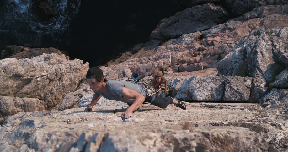 A man strains as he climbs a cliff