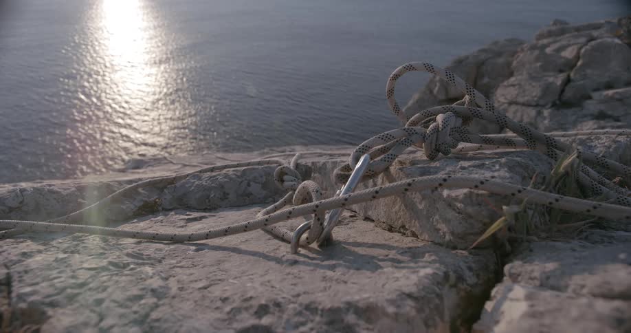 Reinforced ropes attached to a climbing stake at the peak of a mountain next to the sea