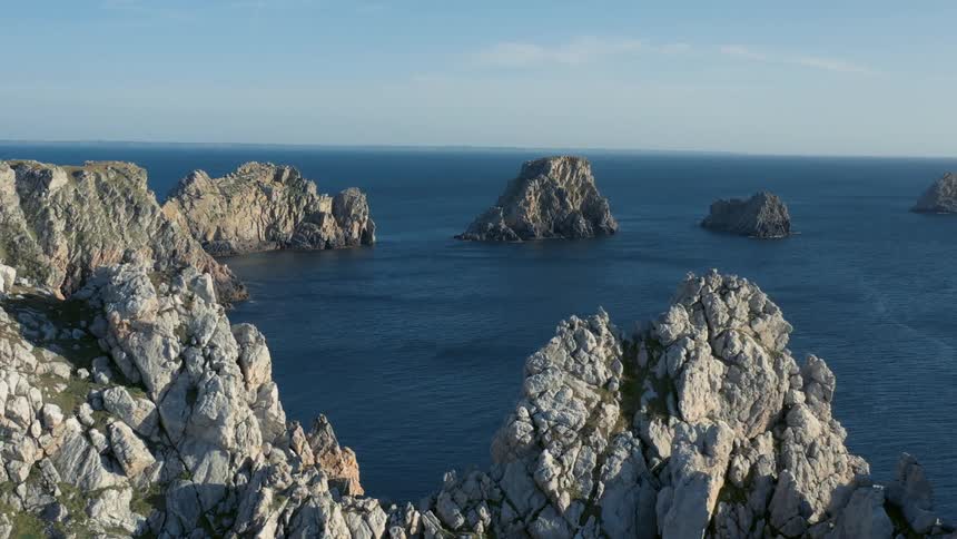 Rocky islands in a still blue ocean on a sunny day