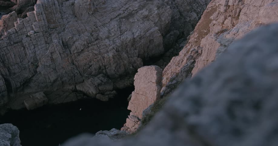 A valley of two stone mountains with a river and there is a bird flying over the place