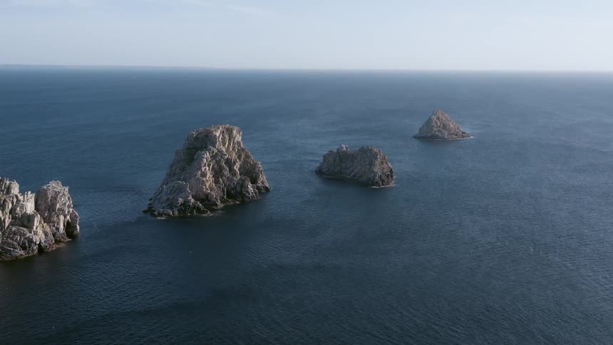 Many large rock formations in the sea lined up