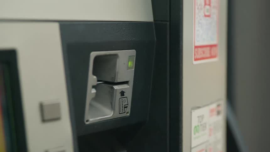 A person puts their credit card in the gas pump