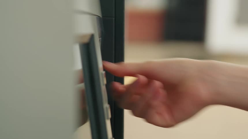 Closeup of a persons hand inserting a card into a fuel pump