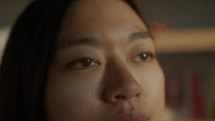 An asian woman looking around the room