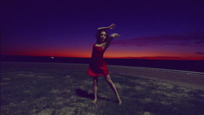 A woman performs an interpretive dance at sunset