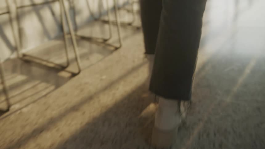 Closeup on a womans legs walking in leather boots on white