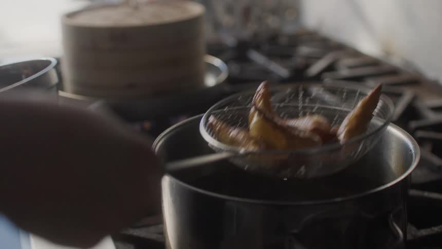 A woman deepfries asian cuisine