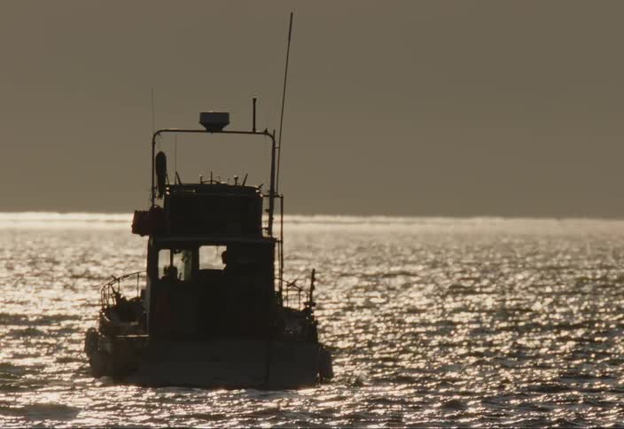 Small boat in the middle of the sea with solar reflection