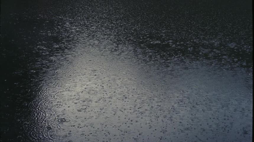 Heavy rain falling on a flat body of water
