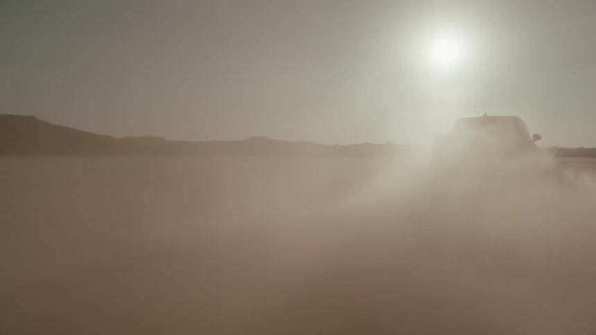 A truck drives through the desert