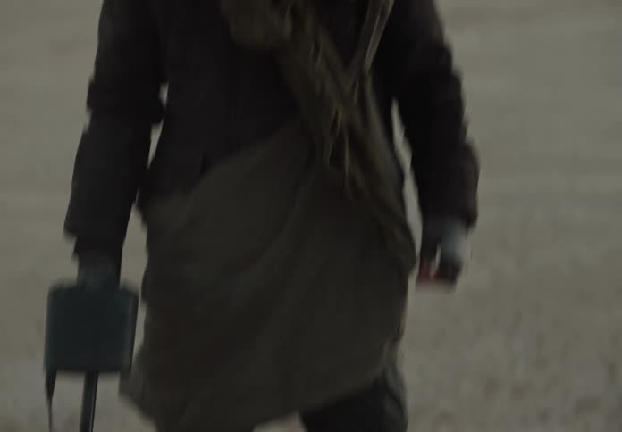 A man uses a metal detector in a desert