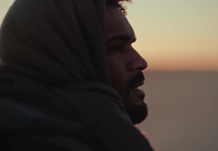 A man looks around in the desert